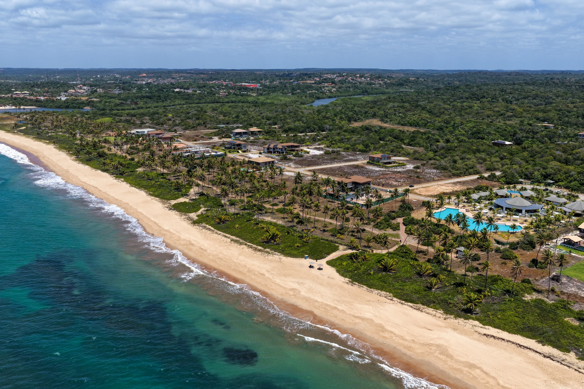 Vista aérea do Clube da Praia, piscina, coqueiral, praia e mar.